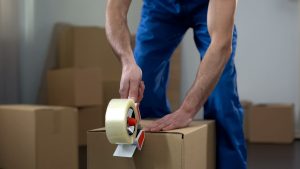 Person sealing a box with tape